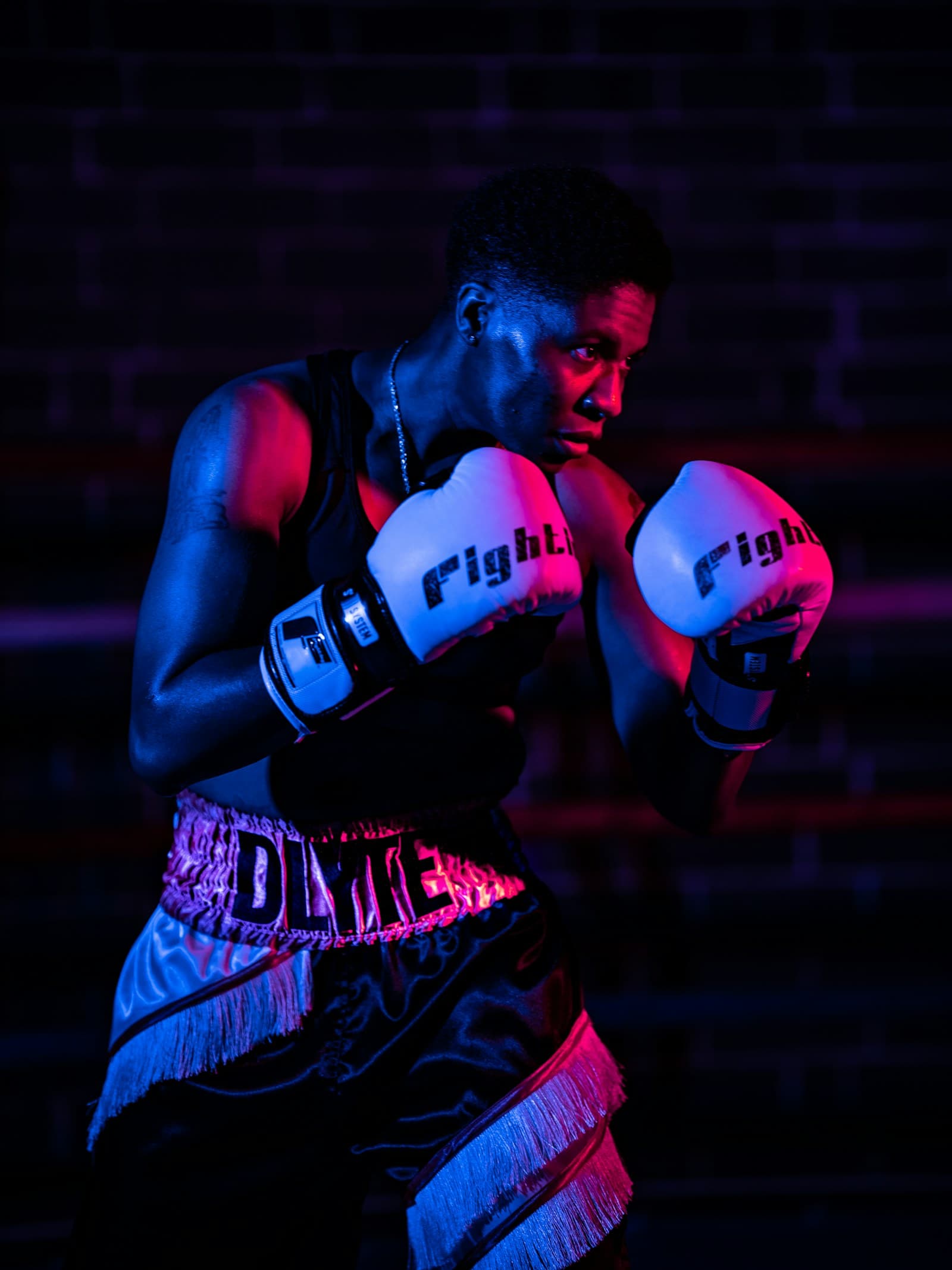 Boxer in red gloves under dramatic red and blue light